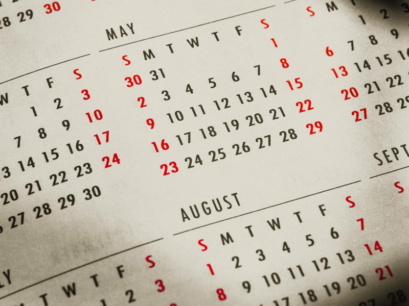 Close-up of a 2023 calendar page capturing sunlight and shadows, highlighting the months of May, June, and August.