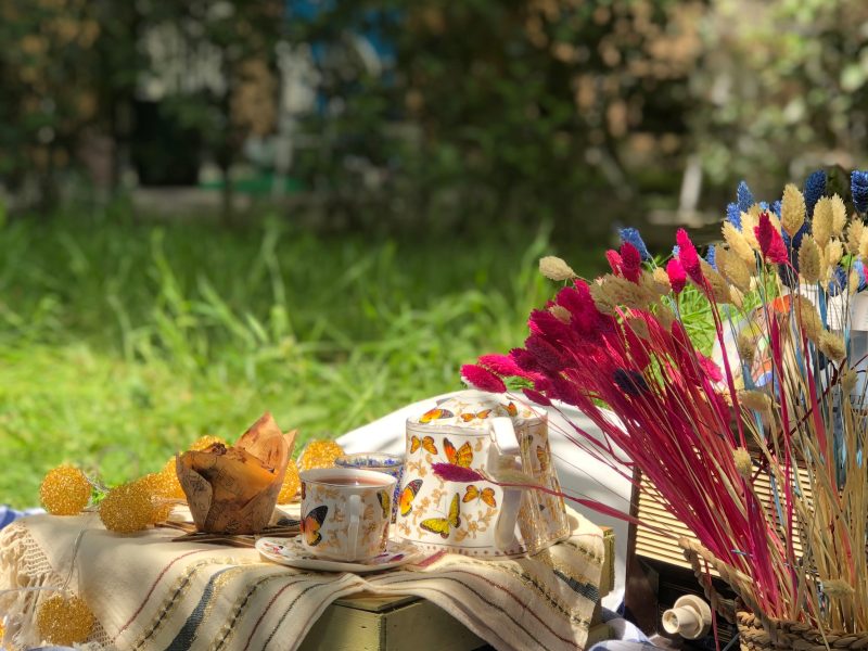 A delightful picnic scene with floral accents and rustic decor in a lush garden setting.